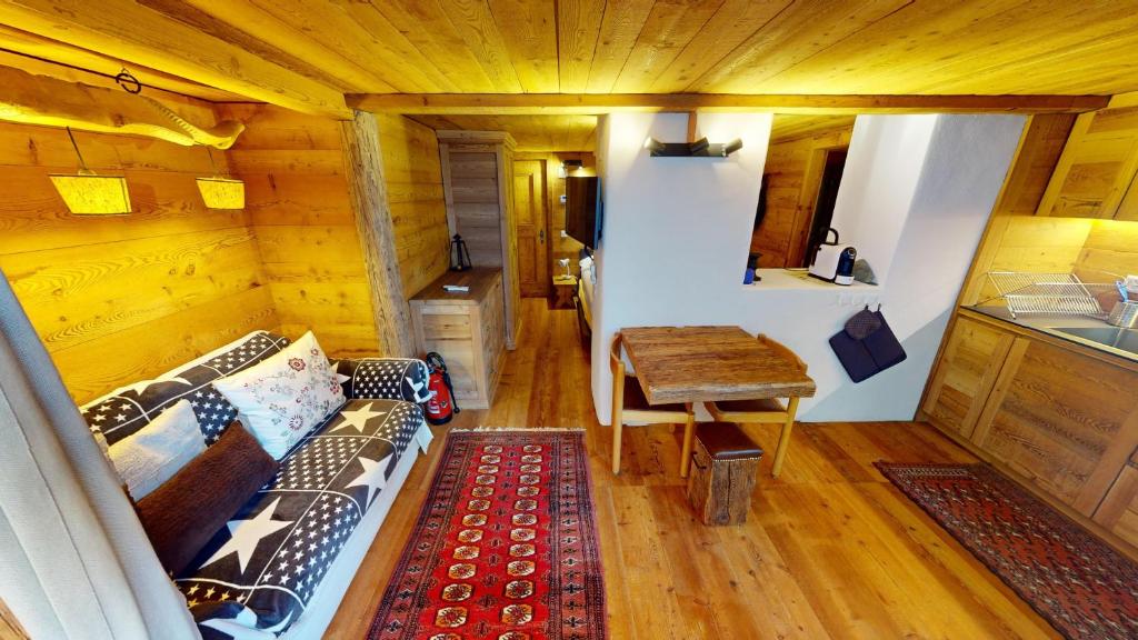 una camera con divano e tavolo in una cabina di Abitaziun Güglia - Silvaplana a Silvaplana