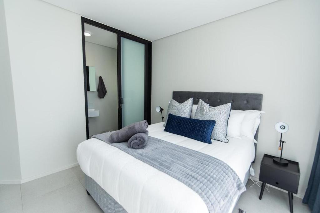 een slaapkamer met een groot wit bed met blauwe kussens bij Bella Retreat Bellamare in Summerstrand