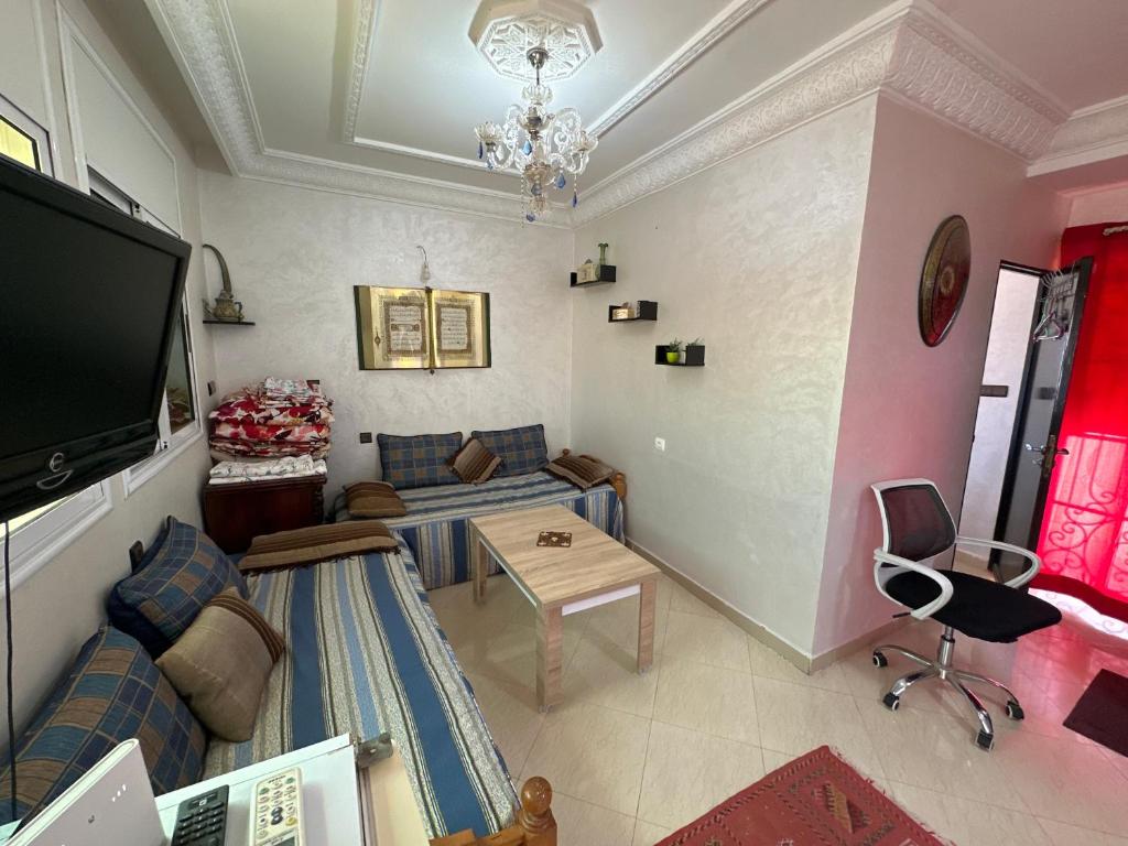a living room with a couch and a tv at Joli studio au centre d'Agadir in Agadir