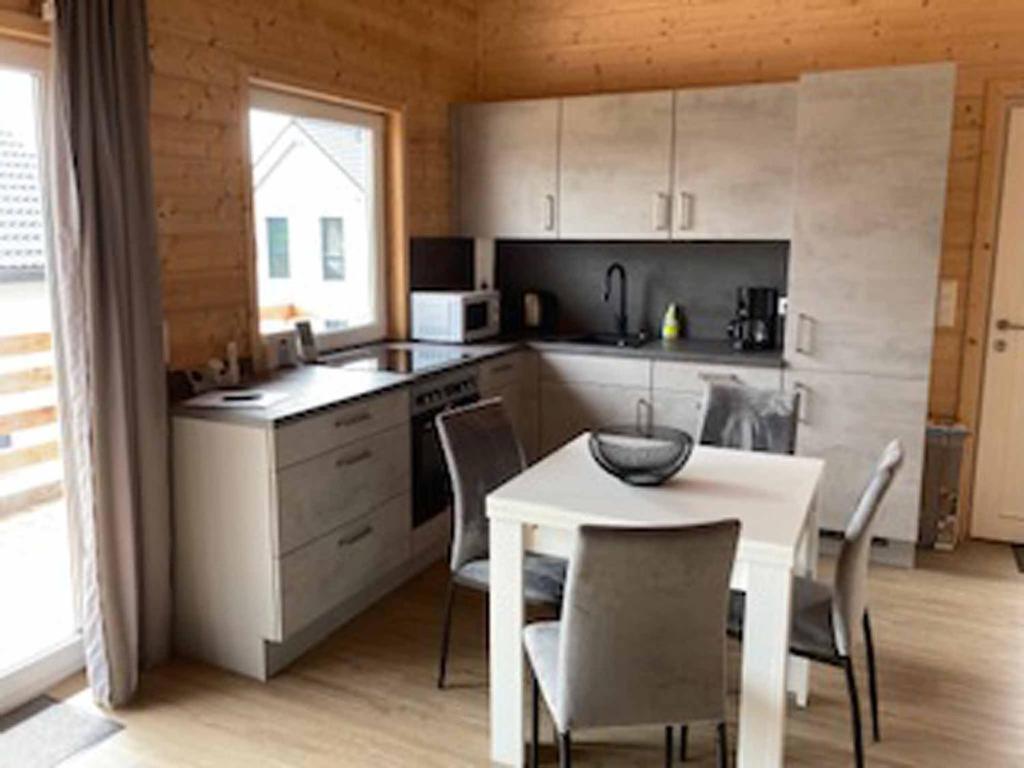 a kitchen with a table and a white table and chairs at Ferienhaus Vogelnest in Marktschorgast