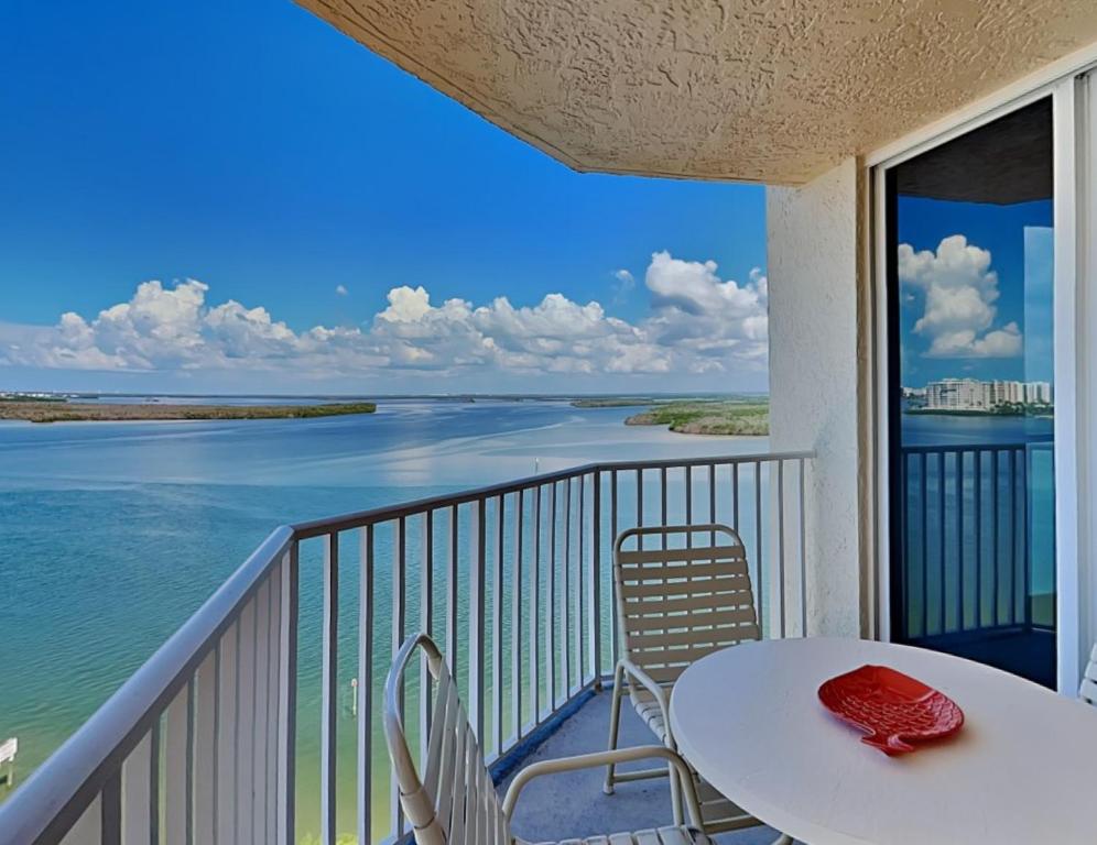 a balcony with a table and chairs and a view of the ocean at Lovers Key Resort 1105 - 1 Bedroom - Sleeps 4 in Fort Myers Beach