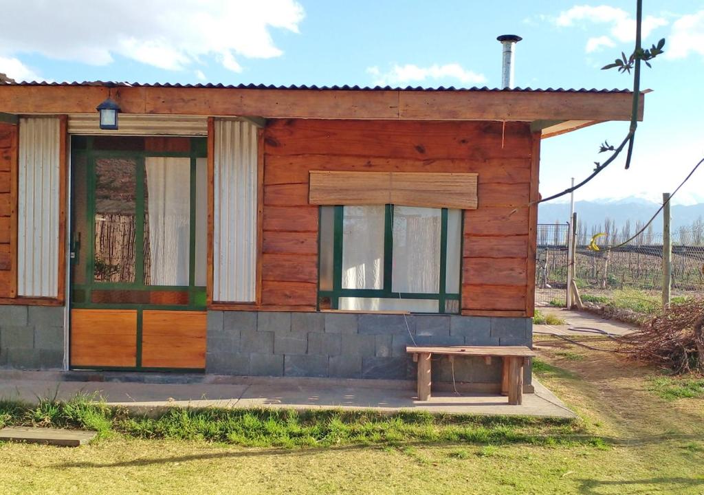 una pequeña casa con un banco delante en El Atelier - Valle de Uco en La Consulta
