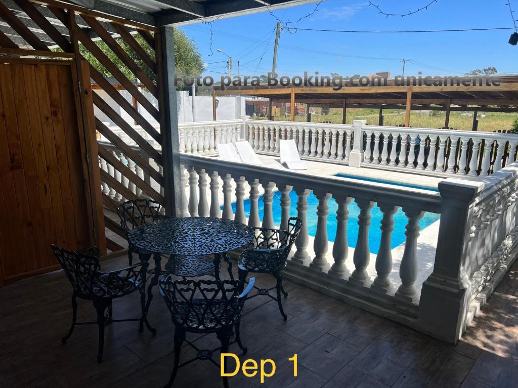 a table and chairs on a porch with a fence at Cabañas Atlantic Breeze in Mar del Plata