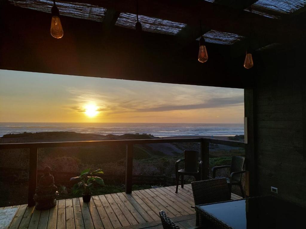 a view of a sunset from the deck of a house at PEZ HOUSE in Pichilemu