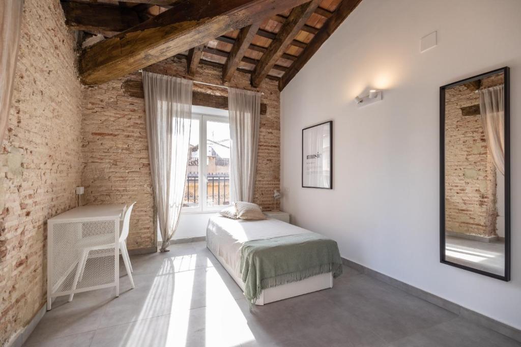a bedroom with a bed and a table and a window at Residencia Universitaria Trinitarios in Valencia