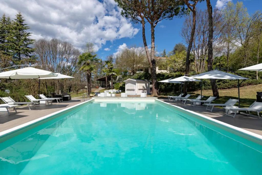 een zwembad met stoelen en parasols bij Saint Paul Luxury Holiday Home by Alterego in San Paolo Solbrito