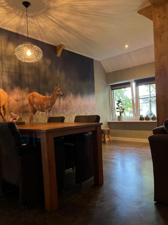 un comedor con una mesa con un ciervo en la pared en Erve Volthebrook, en Rossum