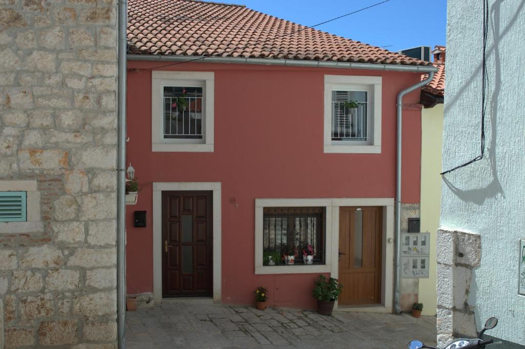 una casa roja con techo rojo en Central Apartment Adria, en Rovinj