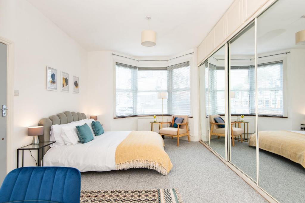 1 dormitorio con 1 cama grande y espejo en Ground Floor En-Suite Room with a Private Kitchen and Parking in a 5-Bedroom House at Hanwell en Hanwell