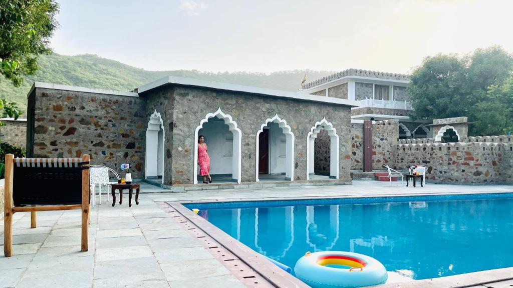 una casa con piscina al lado de un edificio en BluO Sariska - LUXE Stays Collection, en Tehla