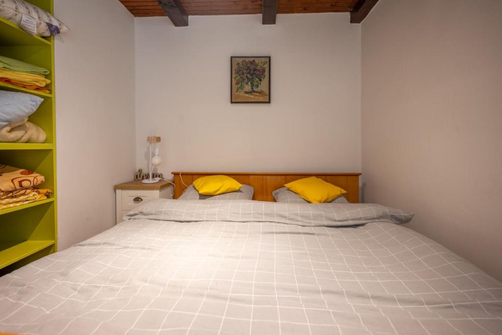 a bedroom with a large white bed with yellow pillows at Svjetlost in Jahorina