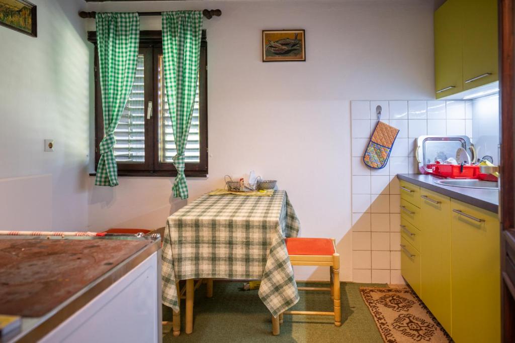 a small kitchen with a table and a sink at Svjetlost in Jahorina