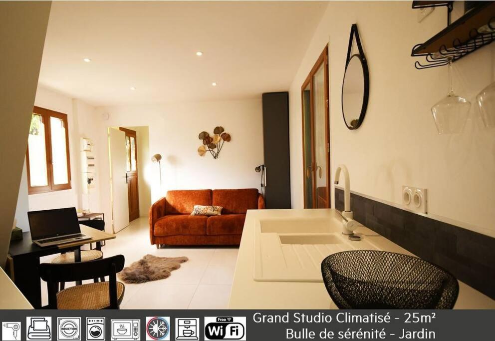 un soggiorno con divano e tavolo di Studio - Confort - Climatisé - Le Refuge de Charles - Jardin a Bures-sur-Yvette