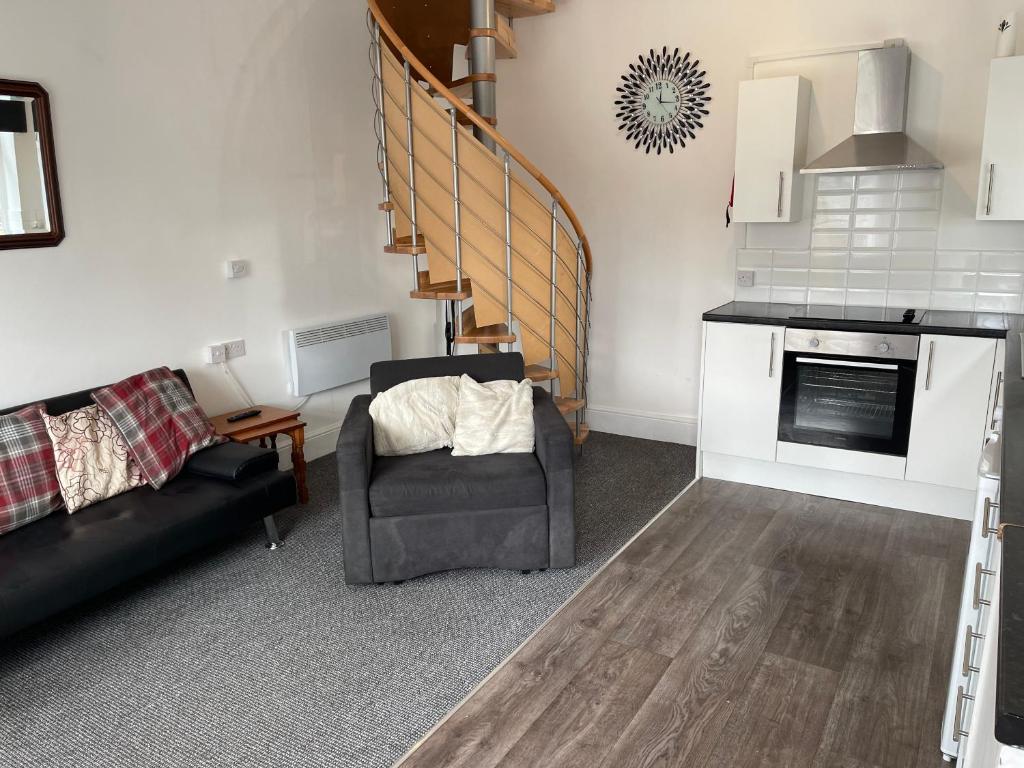 a living room with a couch and a chair at Swinefleet Maisonettes. Airy, Modern & Chic! in Goole