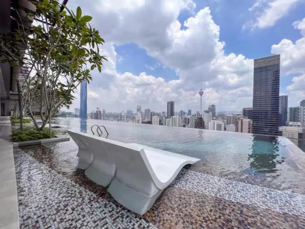 una piscina con una bañera blanca en lo alto de un perfil urbano en Maxhome at Axon Bukit Bintang en Kuala Lumpur