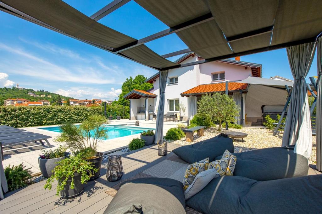 a patio with a couch and a swimming pool at Luxury Villa Sušanj in Matulji