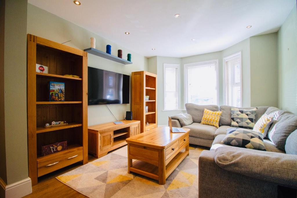 a living room with a couch and a tv at Modern 3 bed w/ garden, nr beach in Parkstone