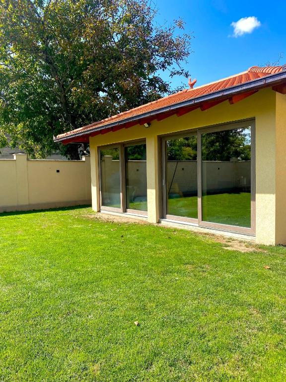 a house with large windows in a yard at CONFORT HOUSE in Lugoj