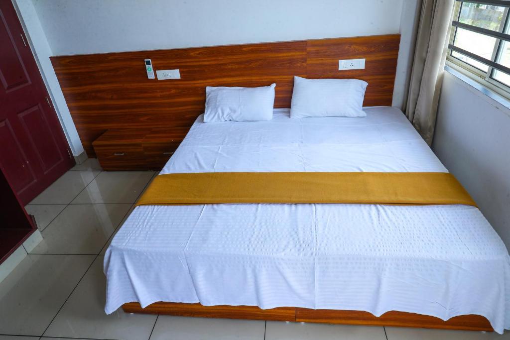 a bedroom with a bed with a wooden headboard at HISHAMS BHAVAN in Alwaye