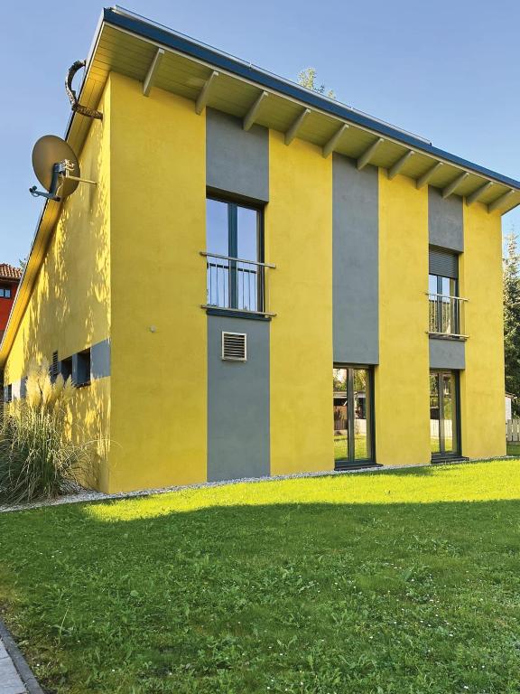 a yellow and gray building with a green yard at Ferienhaus Nicole II, Barrierefrei, mit HIRO Lift in Quedlinburg