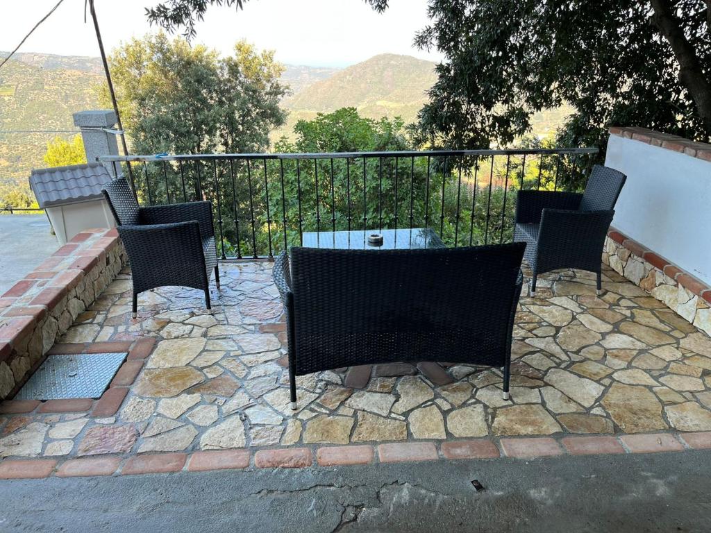 een patio met stoelen, een tafel en een hek bij Casa Jerzu S'essia de su santu in Jerzu