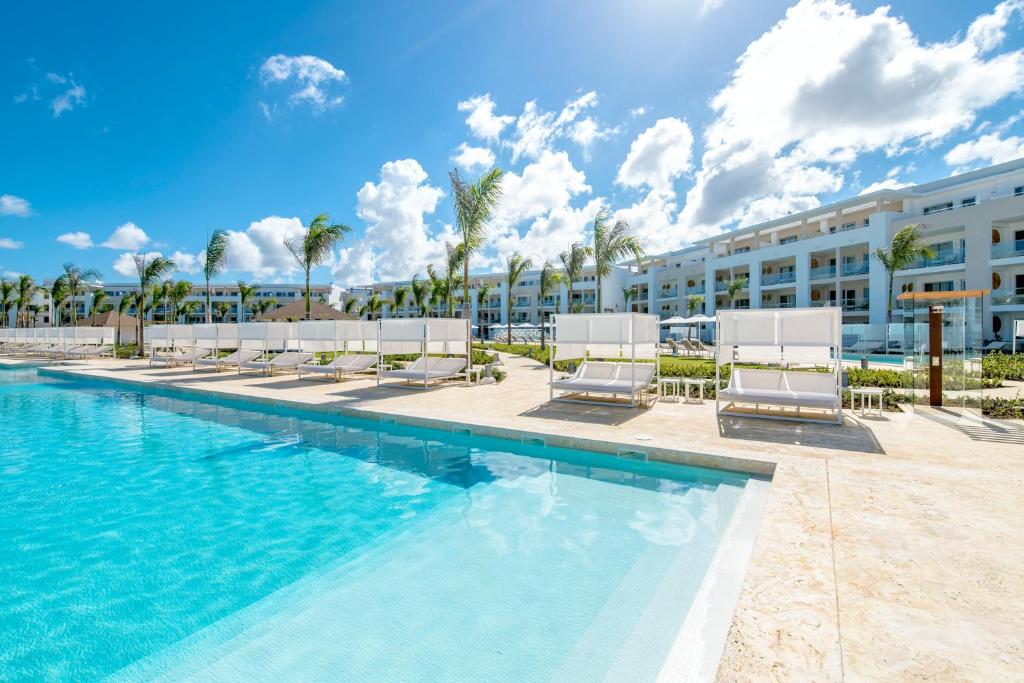 un complejo con piscina con tumbonas y un edificio en Paradisus Grand Cana, All Suites - Punta Cana -All Inclusive, en Punta Cana