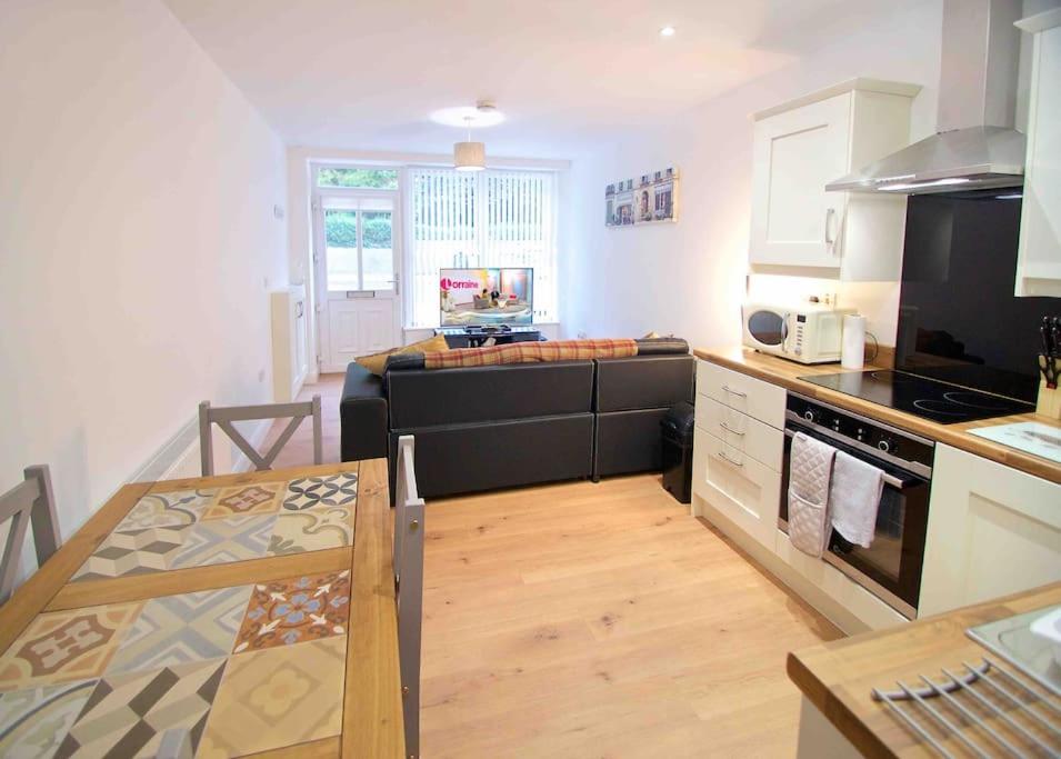 a kitchen with a table and a stove top oven at Newly refurbished flat, 1 min from Galgorm resort in Cullybackey