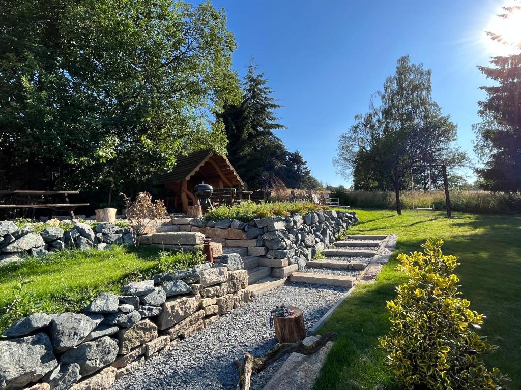 a stone retaining wall in a garden with a stone path at BERGLAGE - Das UrlaubZuhause in Braunlage