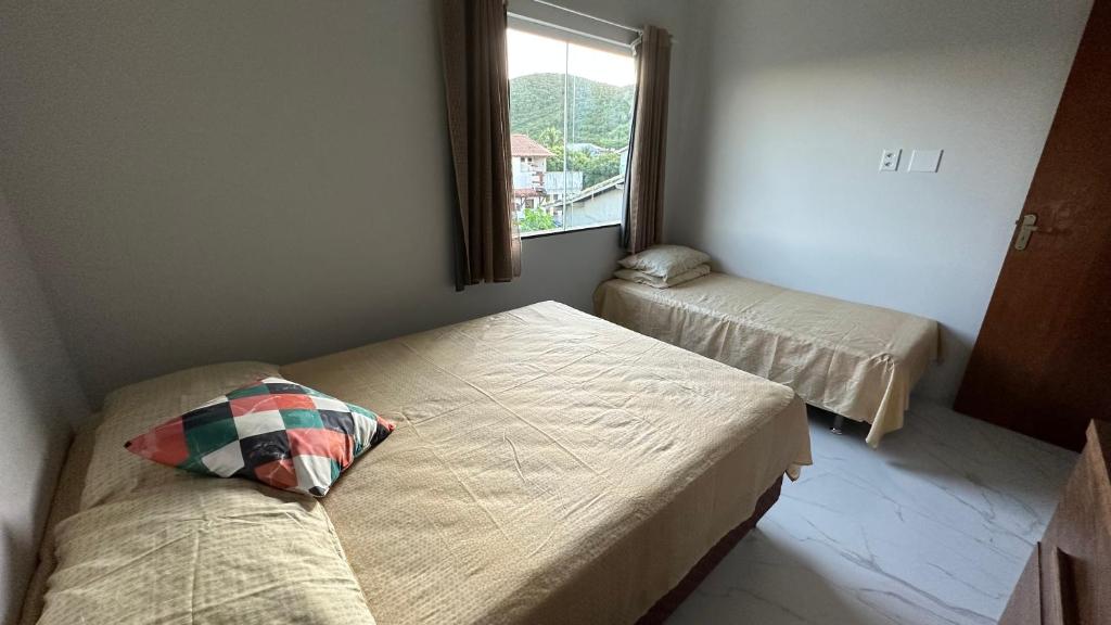 um quarto com 2 camas e uma janela em Casa Pero Oficial em Cabo Frio