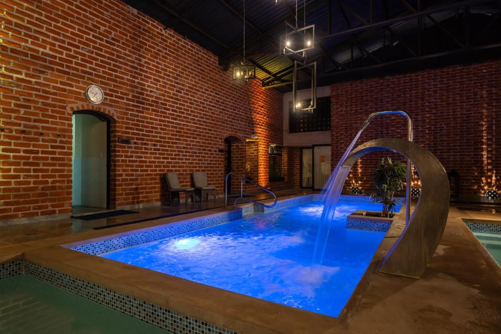 a pool with a water slide in a brick building at Quindeloma Art Hotel & Gallery in Riobamba