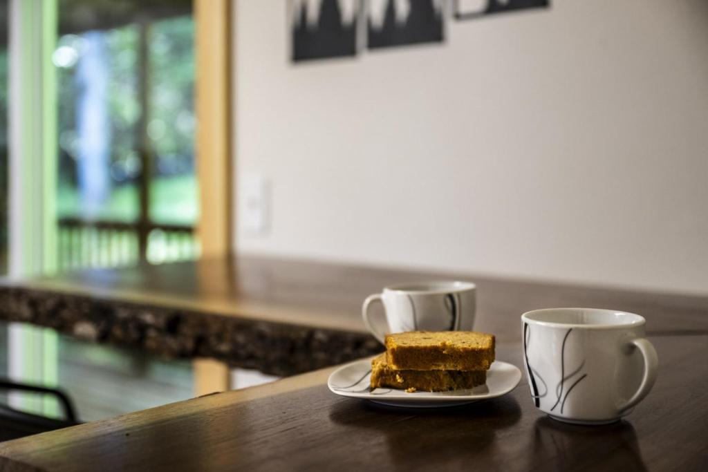 a piece of cake and two coffee cups on a table at Hidden Forest Spa Sauna Nature Secluded 93 acres in Sevierville