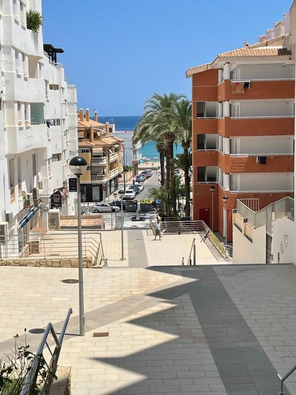 a city street with buildings and the ocean in the background at Casa de Perlas in El Campello