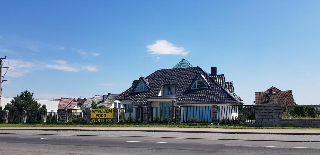 dom z dachem gambrel na ogrodzeniu w obiekcie Tulipan w mieście Krapkowice