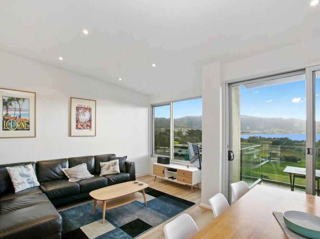 a living room with a couch and a table at Bay Vue - Absolute Oceanviews in Apollo Bay