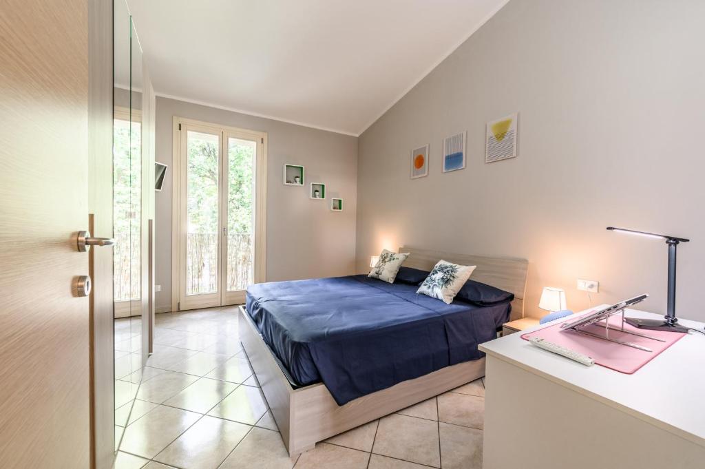 um quarto com uma cama e uma secretária num quarto em Moderna Suite con ampio terrazzo - Free WiFi & Parking em SantʼAgata sul Santerno
