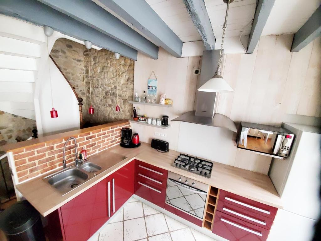 mit Blick auf eine Küche mit roten Schränken in der Unterkunft Les Marionnettes, Maison de ville 80m2 avec terrasse in La Rochelle