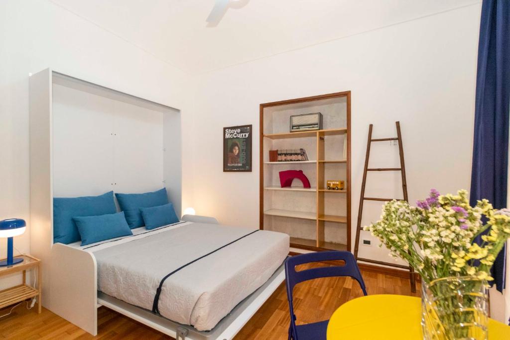 ein Schlafzimmer mit einem Bett mit blauen Kissen und einer Leiter in der Unterkunft Porta Nuova Comfy Studio in Turin