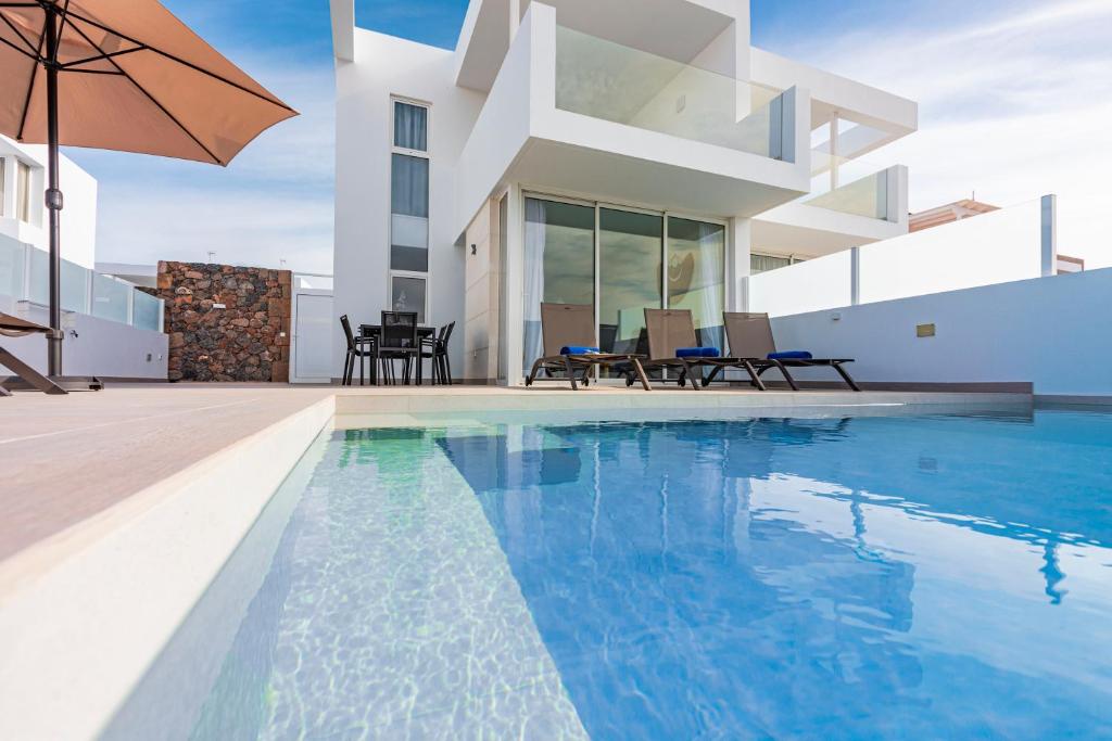 a villa with a swimming pool and a house at VILLA MARACUYÁ in Tías