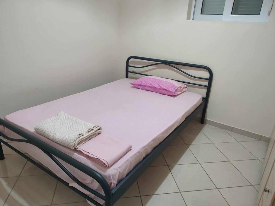 a small bed with pink sheets and pillows on it at Calm & equipped vacation house 