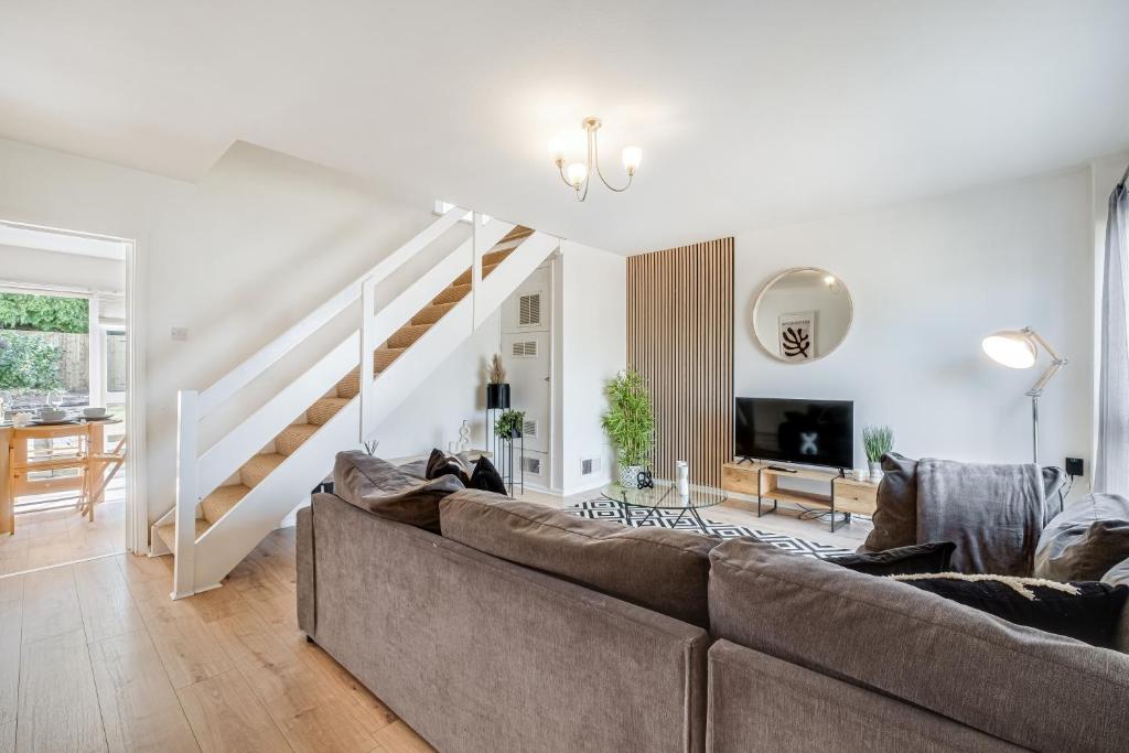 a living room with a couch and a staircase at Spacious and Pristine Home - Free Parking in Northampton