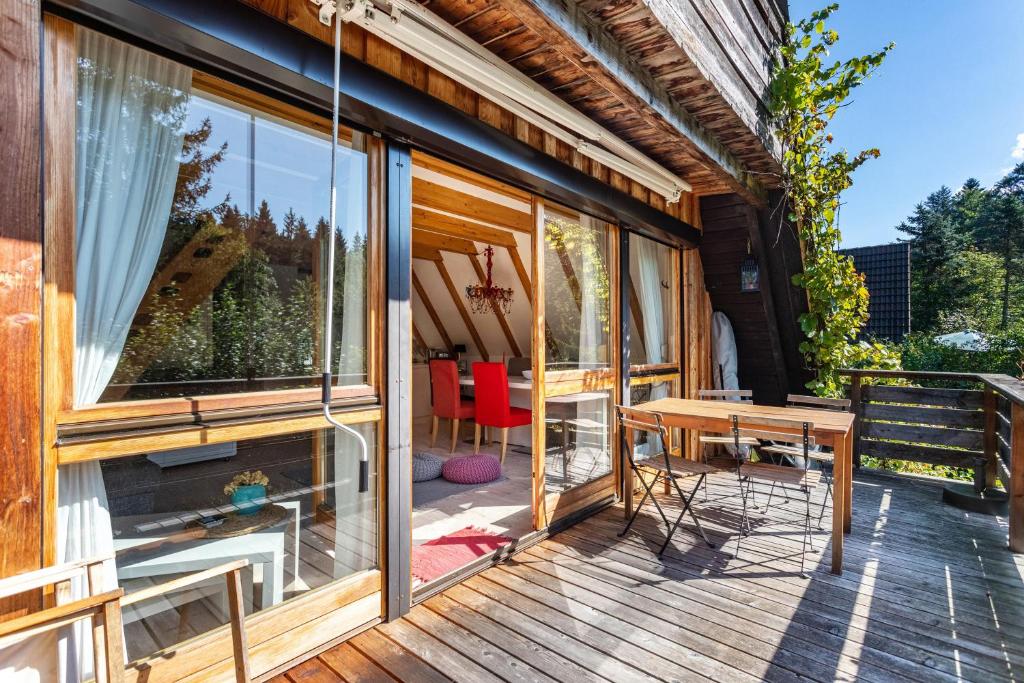 錫格斯多夫的住宿－Charmantes Ferienhaus mit Garten，木制甲板上配有桌椅