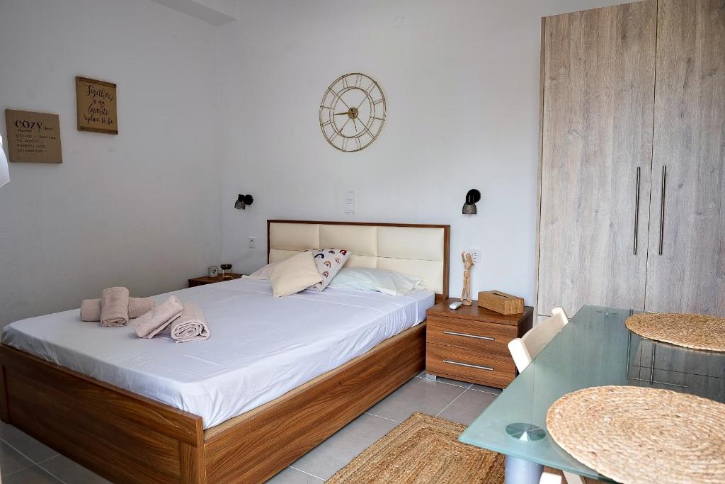 ein Schlafzimmer mit einem Bett, einem Tisch und einer Uhr in der Unterkunft Nikos apartment in Malia