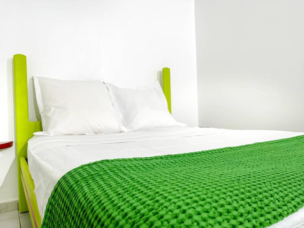 een bed met een groene deken erop bij Mosaïk kréyol in Le Moule