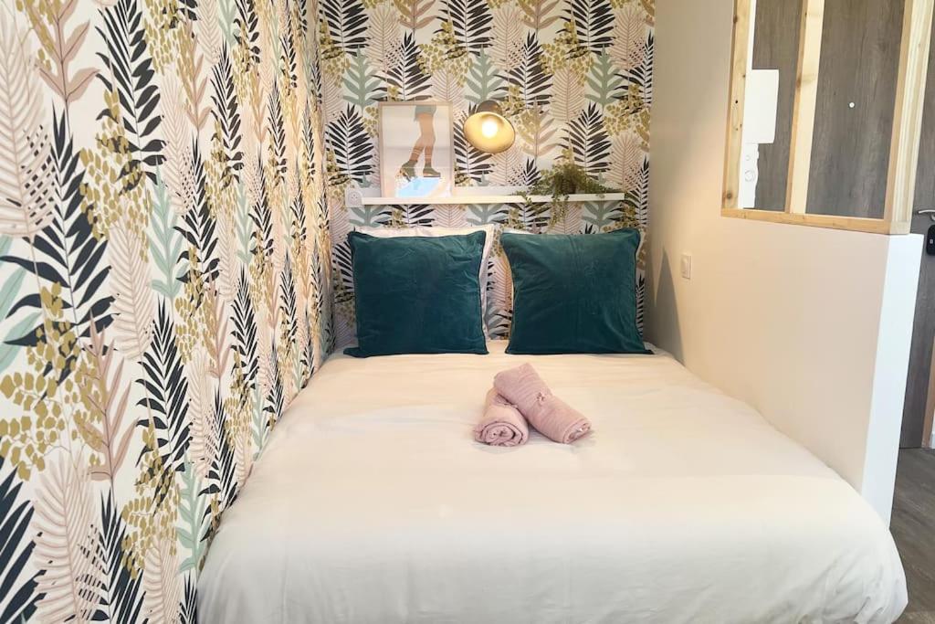 a small bed with a pink pillow on top of it at Studio 1 Ananas cosy proche plages et commerces in Saint-Nazaire