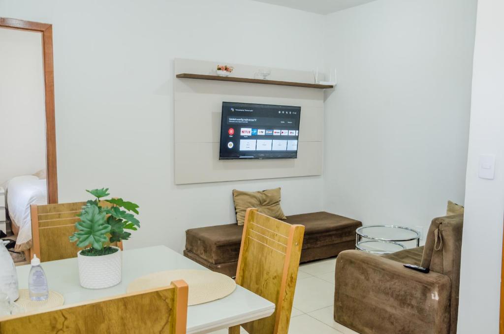 uma sala de jantar com mesa e cadeiras e uma televisão em Prox ao hospital HRT e Anchieta e faculdade - wifi- netflix - ar-condicionado em Taguatinga