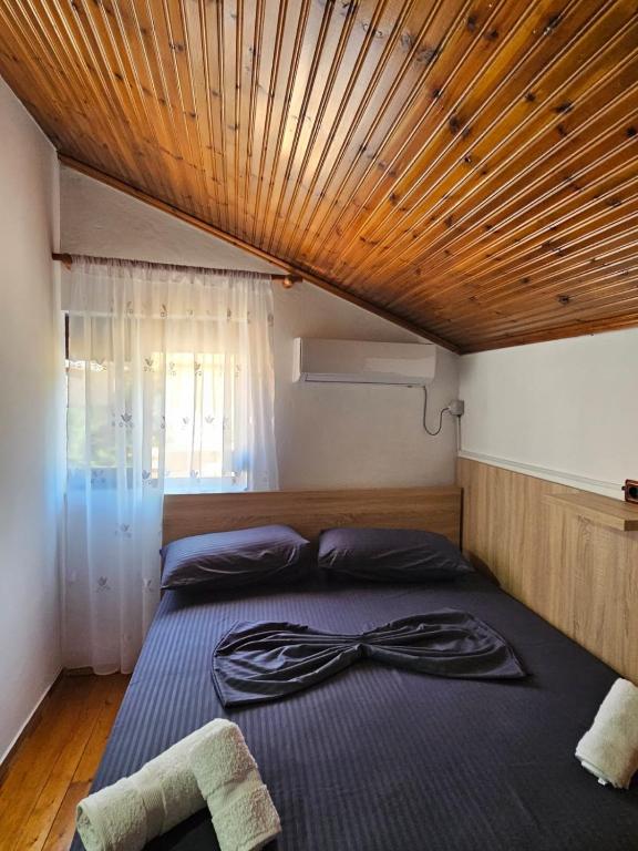 a bedroom with a large bed with a wooden ceiling at Castle - inside,Voga Guesthause in Krujë