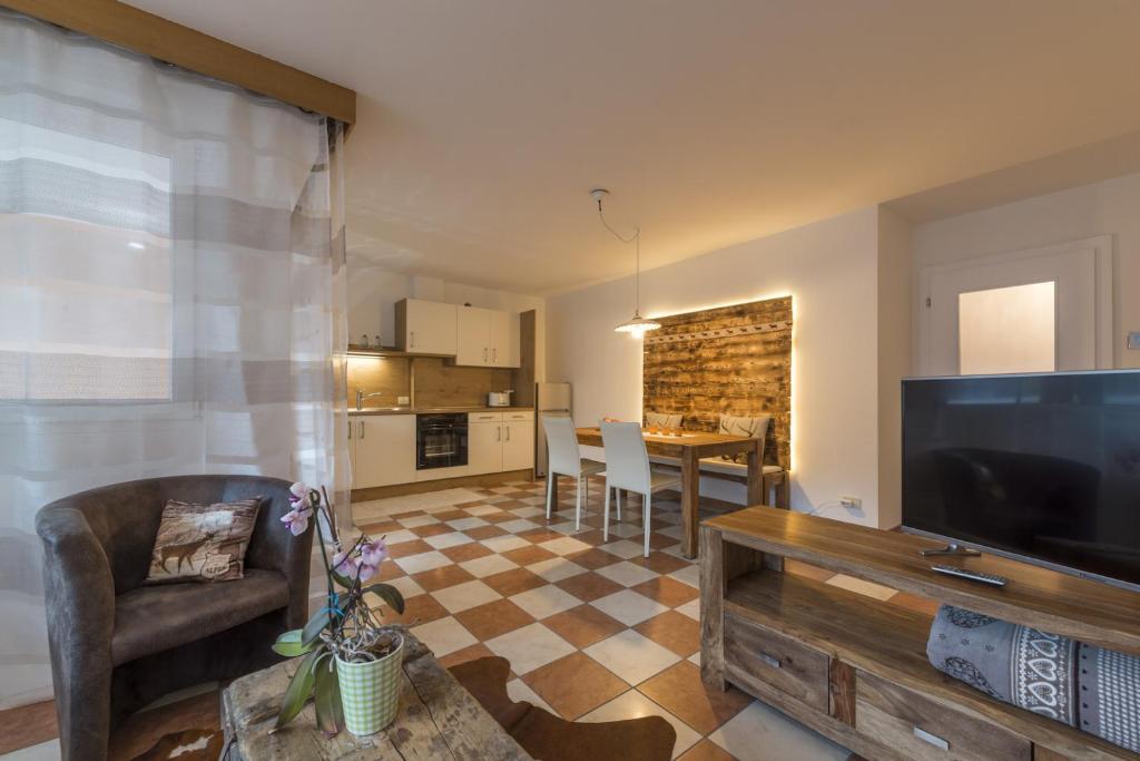 a living room with a large flat screen tv and a kitchen at Apartment Sofia in Mühlbach