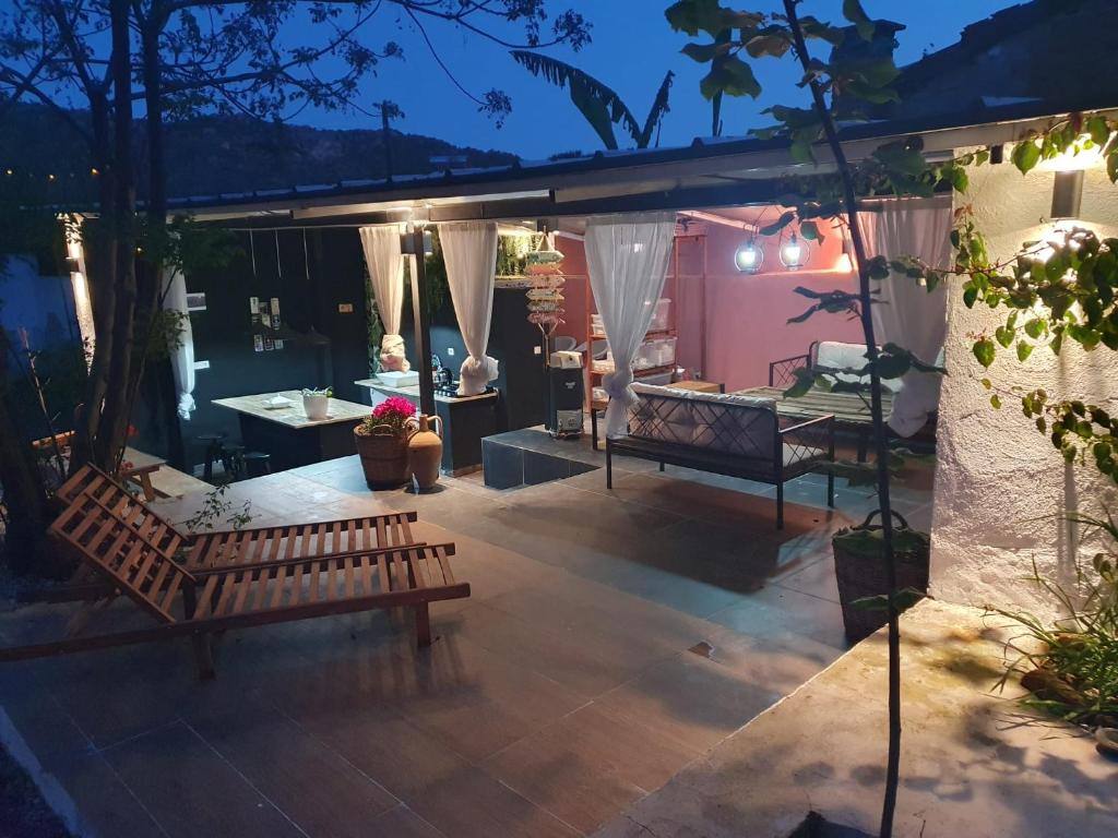 a patio at night with a bench and a table at BayKus Guesthouse-Konukevi in Soke