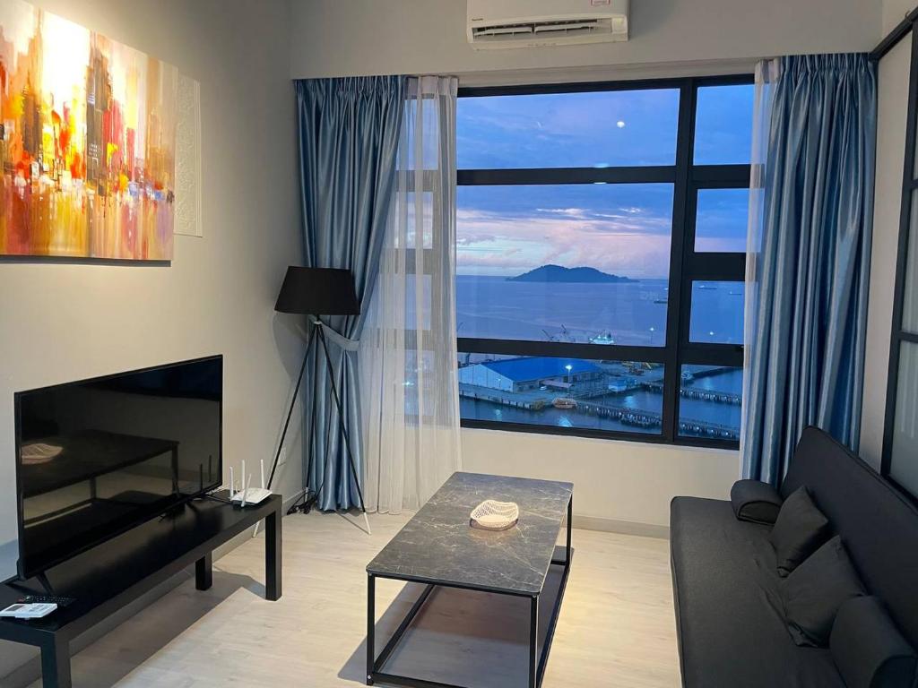 a living room with a couch and a large window at LW Suite at JQ Seaview 2BR High Floor & Wi-Fi in Kota Kinabalu