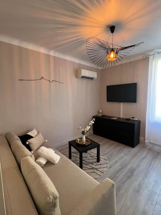 ein Wohnzimmer mit einem Sofa und einem Flachbild-TV in der Unterkunft Charmant T1 climatisé en centre ville / Paradis in Marseille
